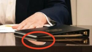 Closeup of an Image of Donald Trump in the Oval Office, with a detail marked in red.